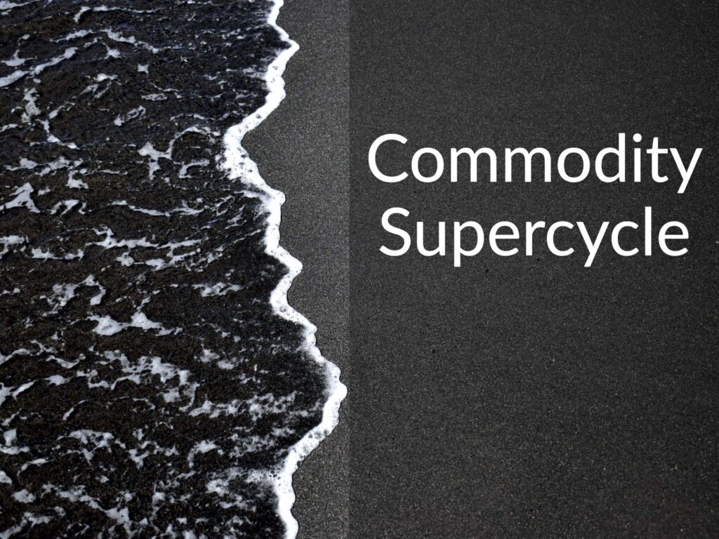 A wave on a black sand beach. Caption says "Commodity Supercycle"